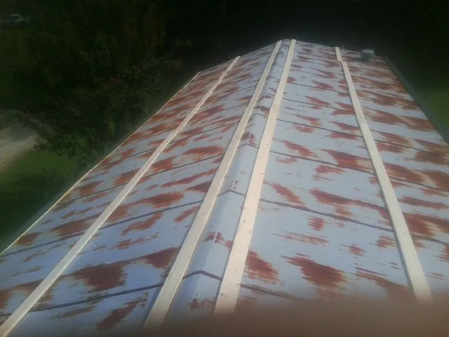 Rusted metal roof panels with new wood purlins before replacement — Storm Damage Roof Repair in Confluence by Roofing Brothers