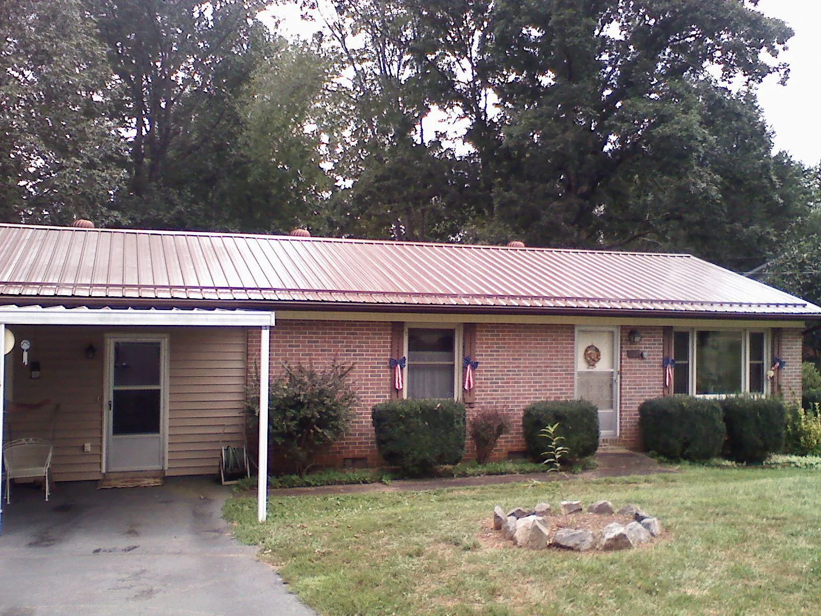Bronze metal roof and carport on a brick ranch home — Roof Repair work by our crew in Confluence