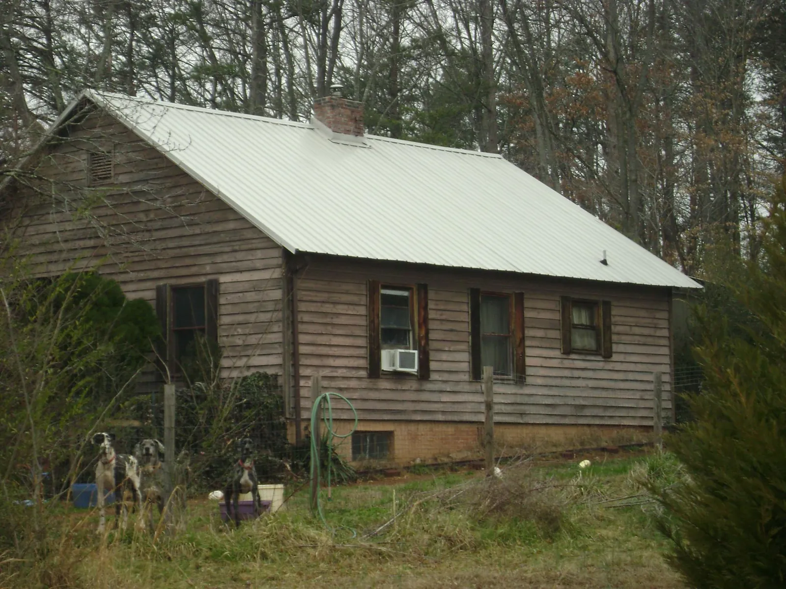White metal roof on an old wood sided farmhouse, from a Metal Roof Installation job in Confluence